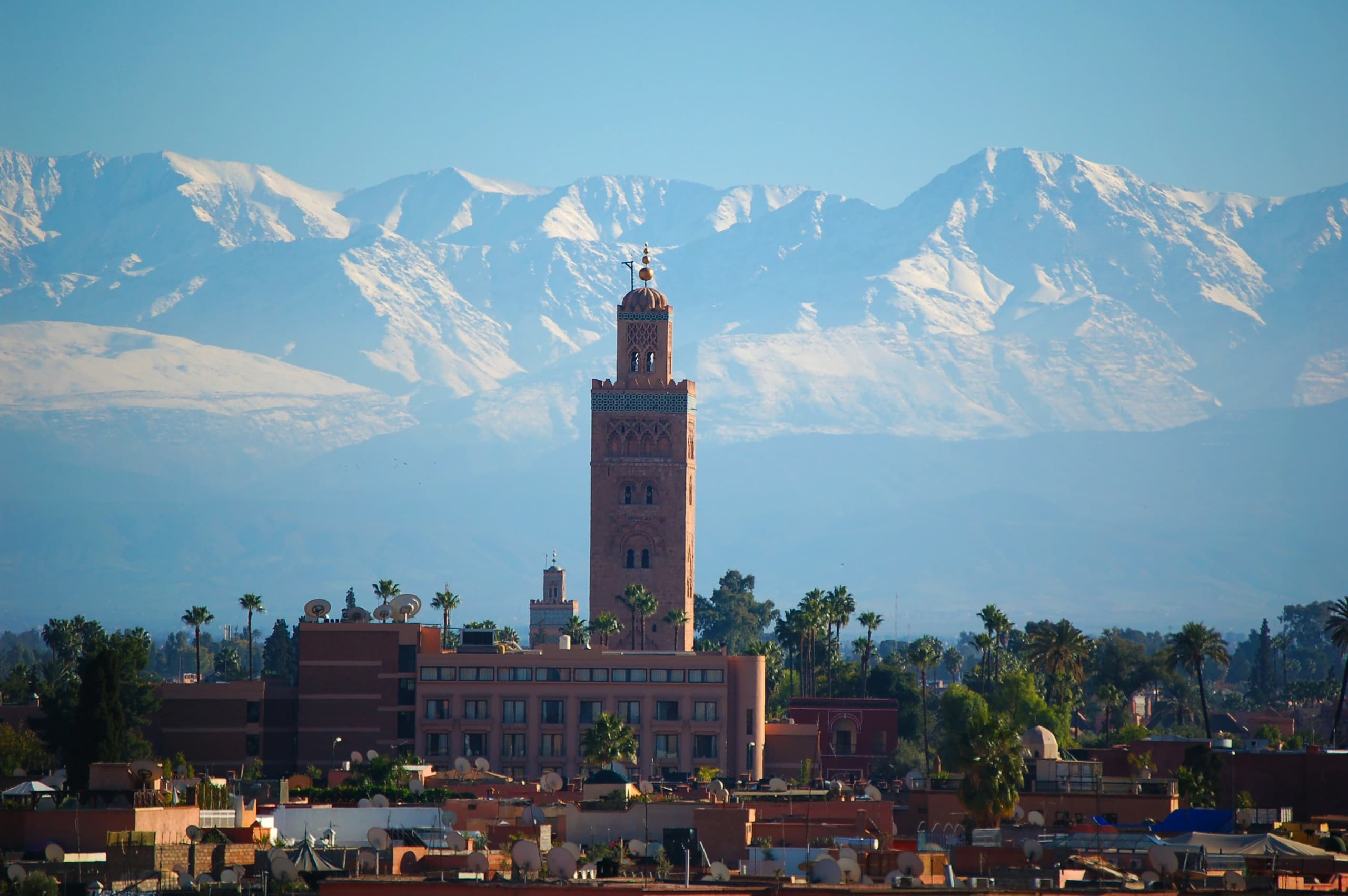 The Koutoubia minaret rising above Marrakech, with the snow-capped High Atlas behind
